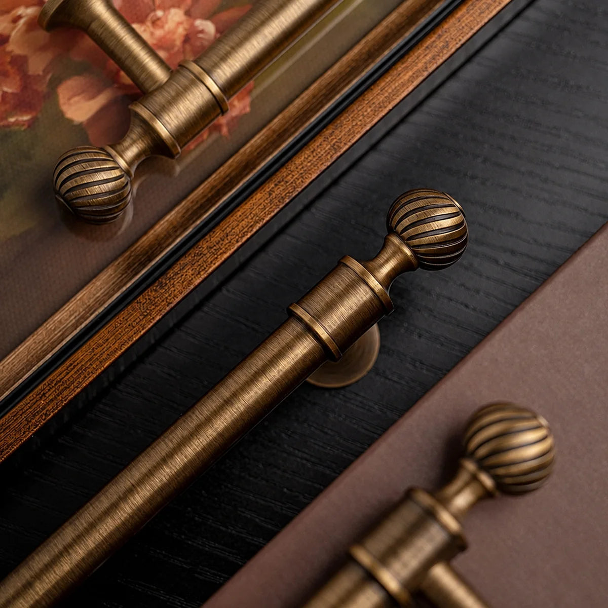 Close-up of spiral-grooved ball finials and smooth brass grips