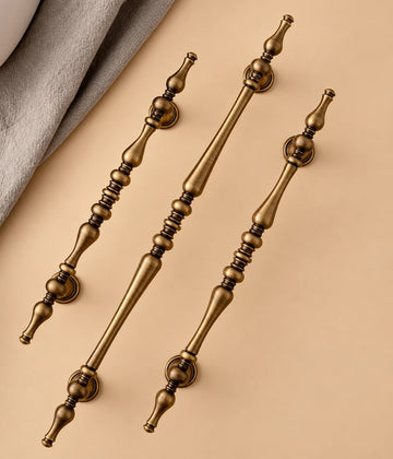 Three antique brass turned spindle cabinet pulls with decorative finials