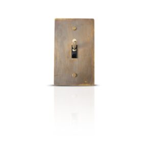 Vintage-inspired multi-gang brass toggle switch plates with an antique finish for classic interior control