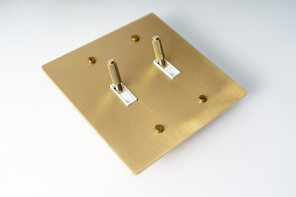 Satin Gold Knurled Two-Gang Toggle Switch - Textured dual switch panel with a stylish gold finish