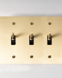 Three-Gang Satin Gold Brass Toggle Switch - Triple-toggle switch in a durable satin gold brass finish