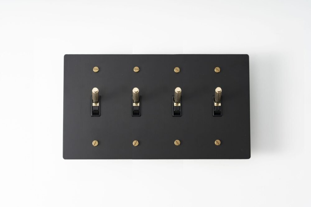 Four-Gang Black Brass Plate with Golden Knurled Toggle Switch - Sleek quadruple-toggle switch in a black brass finish, accentuated by golden knurled detailing for a sophisticated touch