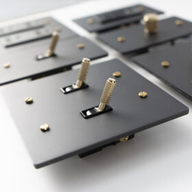 Knurled toggle brass switch in matte black wall plate