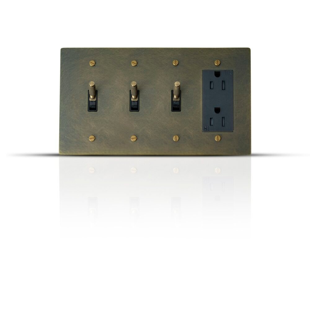 A luxurious brass panel featuring three toggle switches and a Decora outlet, blending classic elegance with modern functionality for a refined electrical setup.