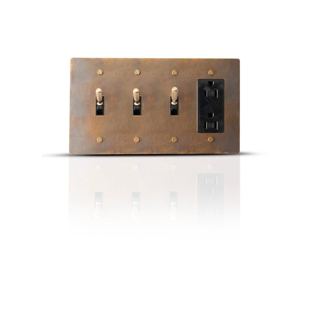 A luxurious brass panel featuring three toggle switches and a Decora outlet, blending classic elegance with modern functionality for a refined electrical setup.